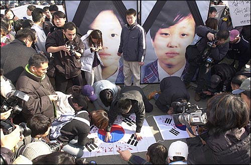 지난 21, 동두천 캠프케이시 앞에서 벌어진 미군장갑차 여중생 사망사건 군사재판 항의시위에서 태극기에 혈서를 쓰고 있는 시민들. 